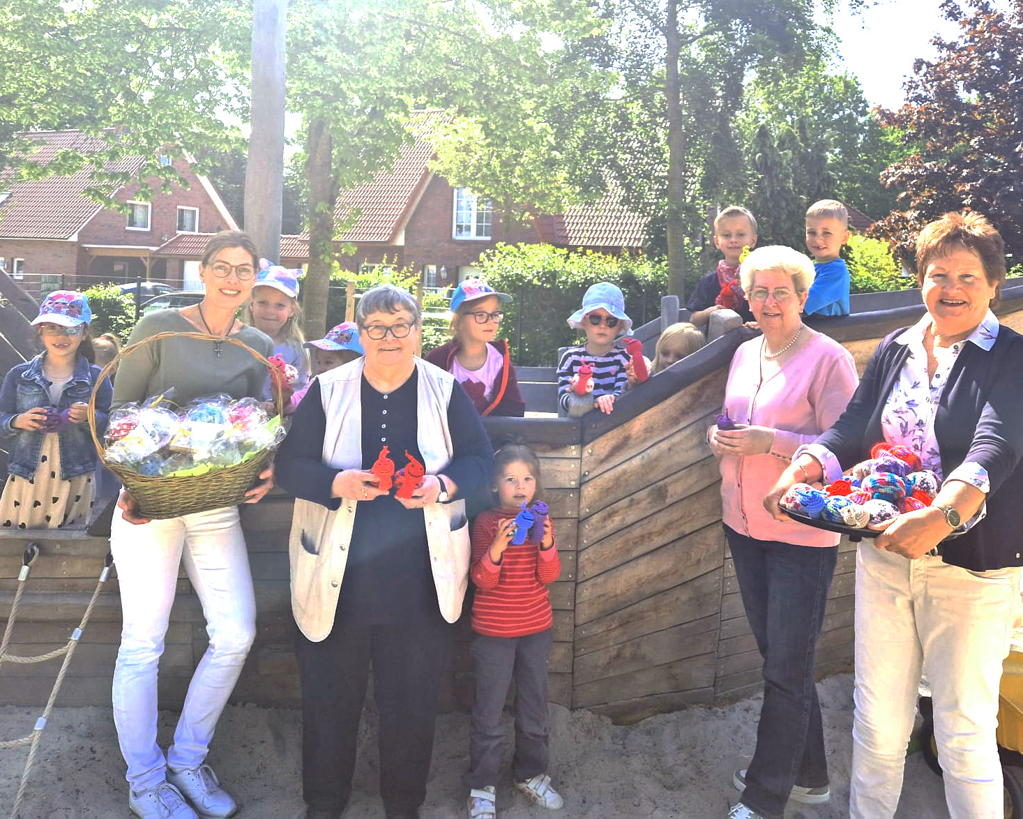 Einrichtungsleiterin Gaby Tepe (links) und die Kinder der Kita Arche freuen sich über die handgefertigten kleinen Tierchen,  die Hedwig Buschmann (rechts) von der Ehrenamtsagentur Cloppenburg und ihre Helferinnen überreichten. Foto: Kita Arche